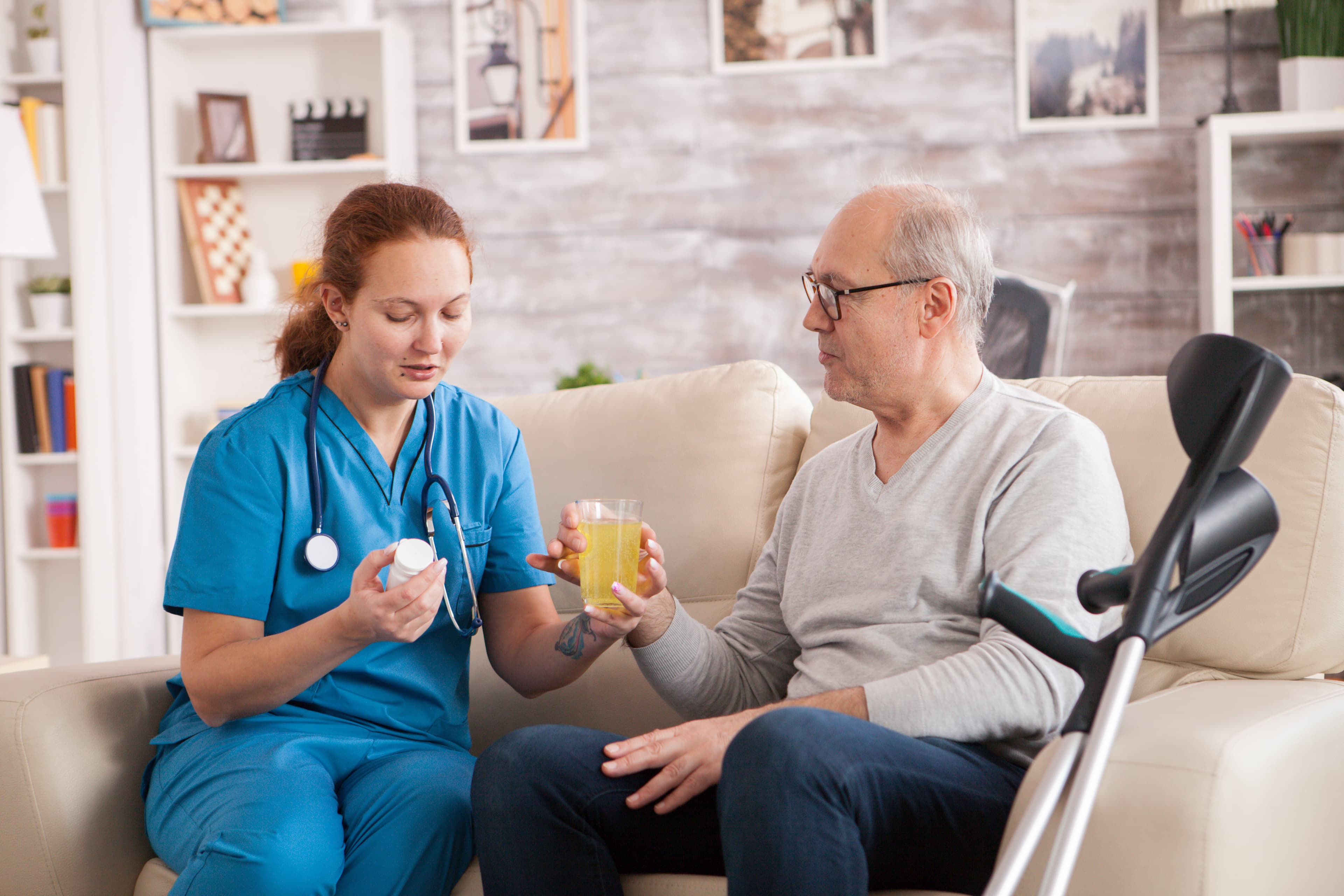 Nurse helping a senior man take his medication at home